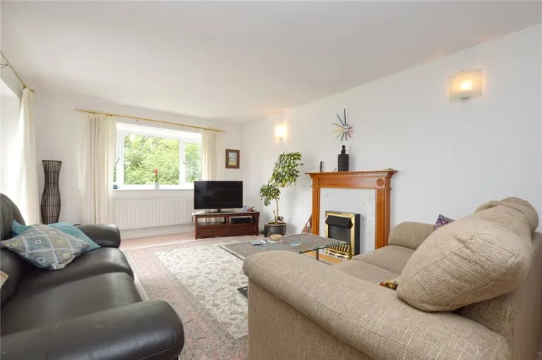 A spacious lounge with log burner and large window.