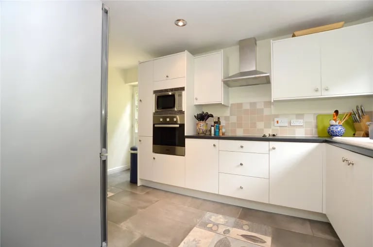 The open plan kitchen with tiled floor and fitted units and appliances.