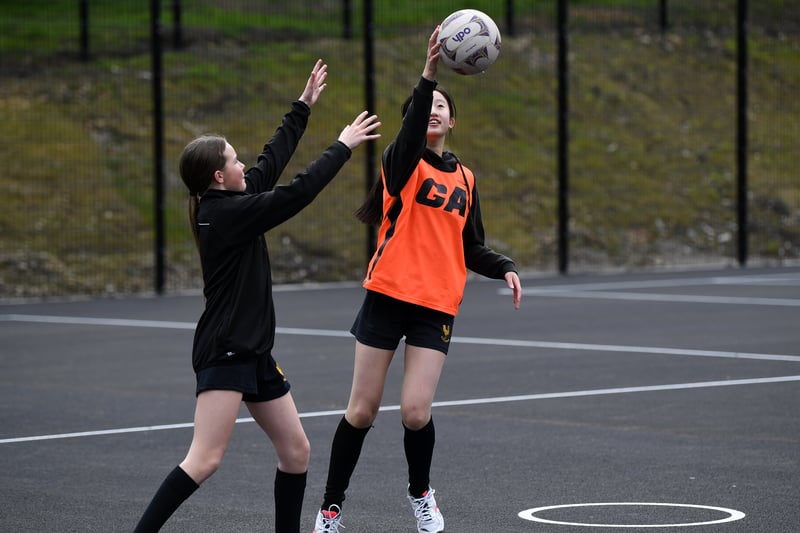 Students from the the school's netball team train on the new pitch.
