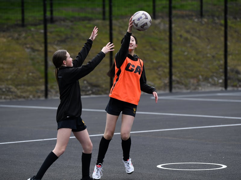 Students from the the school's netball team train on the new pitch.