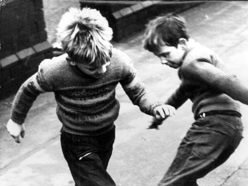 Two boys playing football in the Attercliffe area of Sheffield during the 1960s