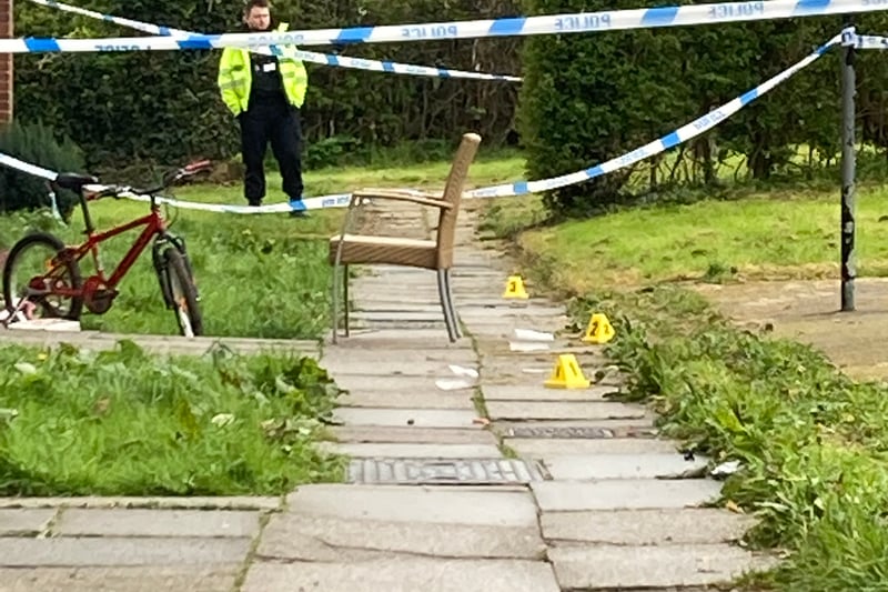 Yellow evidence markers can be seen inside the cordon.
