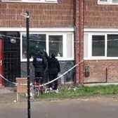 Police officers point at apparent bullet holes in windows of flats on Lowedges Road, Sheffield. South Yorkshire Police has confirmed multiple shots were fired at the building overnight on April 24.