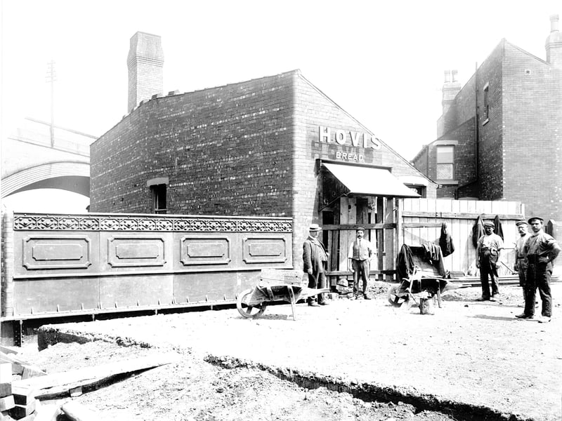 Workmen pose for the camera as they are laying down the surface to a bridge across Low Beck in July 1905.