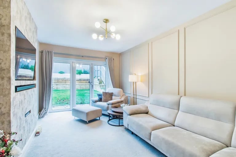 The stylish lounge has glass doors leading onto the rear garden.