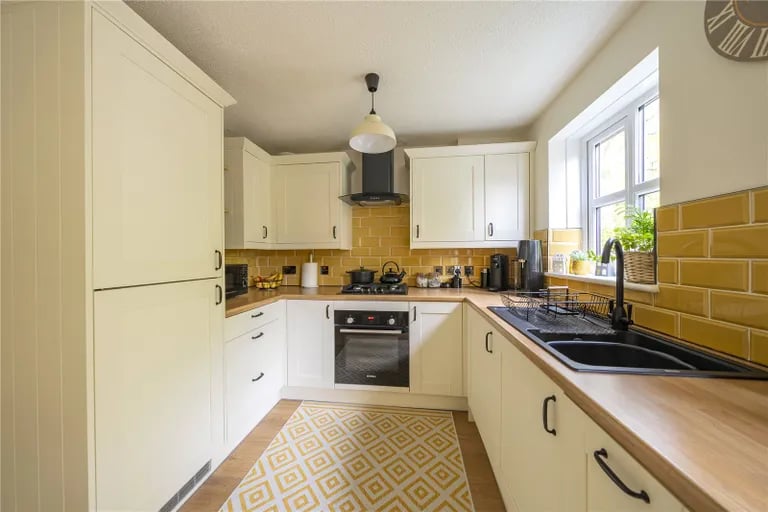 The kitchen has a range of base and wall units as well as integrated appliances.