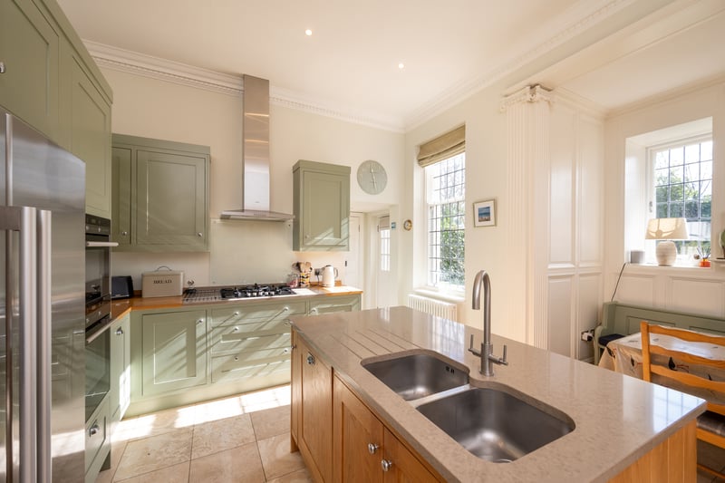 The home features a light and airy solid oak kitchen with island. A separate utility room ensures noise from appliances is kept to a minimum in social spaces.