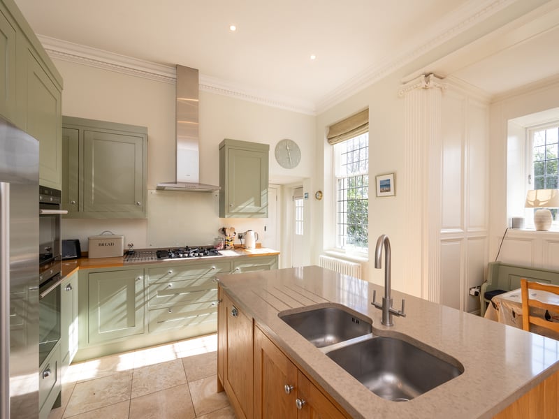 The home features a light and airy solid oak kitchen with island. A separate utility room ensures noise from appliances is kept to a minimum in social spaces.