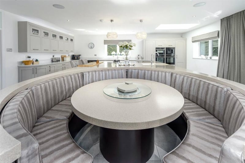 Attached to the kitchen island is a circular dining booth, ideal for informal dining.