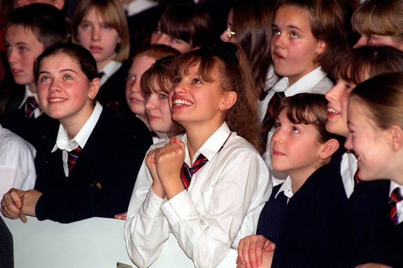 Pupil Simone Pritchard keeps a close eye on boy band 98 Degrees during a performance at the school in  November 1997.