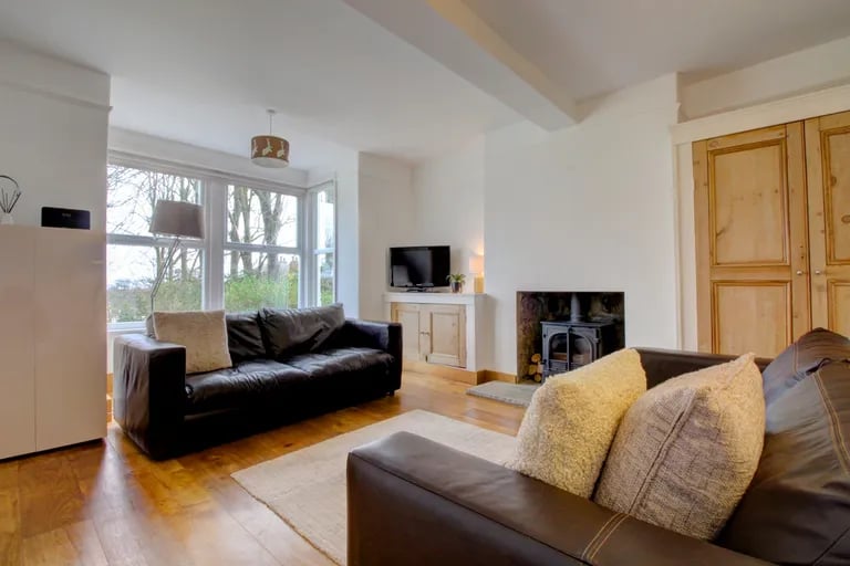 On the other side of the hall is a spacious living room with log burner and bay window.