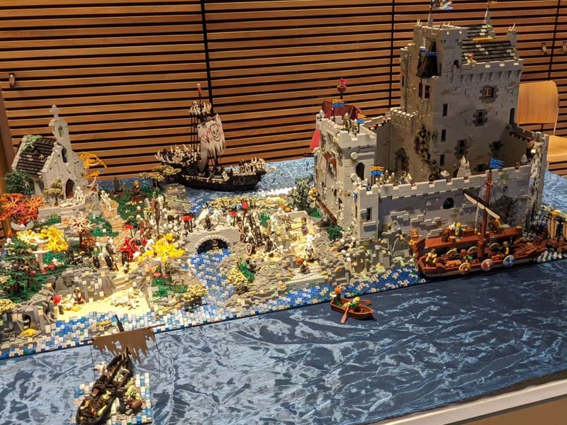 An island scene with a castle, church and boats.