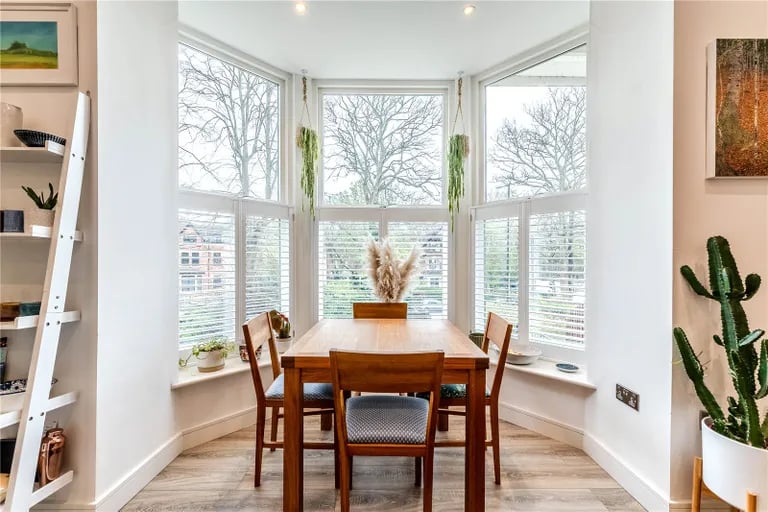 The dining area features a bay window overlooking the gardens.