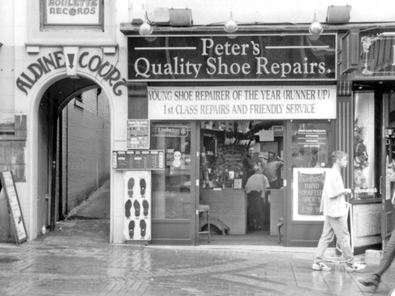 High Street, Sheffield city centre, in June 1996, showing Peter's Quality Shoe Repairs and the entrance to Aldine Court, with a sign for Roulette Records above
