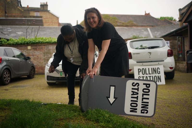 Election workers fix the sign at the polling station at St Alban's Church, south London.