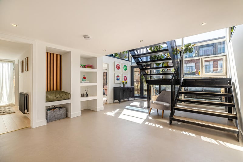 A look inside the generous and welcoming reception hallway with modern microcement flooring, open tread staircase to upper floor, access to the lower living accommodation and patio doors to the private terrace.