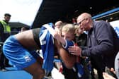 Ethan Laird of Birmingham City is embraced by a fan after handing him his shirt, after Birmingham City are relegated to League One despite defeating Norwich City, after the Sky Bet Championship match between Birmingham City and Norwich City at St Andrews (stadium) on May 04, 2024 in Birmingham, England. (Photo by Cameron Smith/Getty Images)
