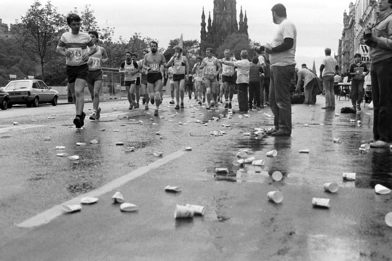 Competitors in the Edinburgh Marathon leave a trail of discarded paper cups in Princes Street, September 1985.