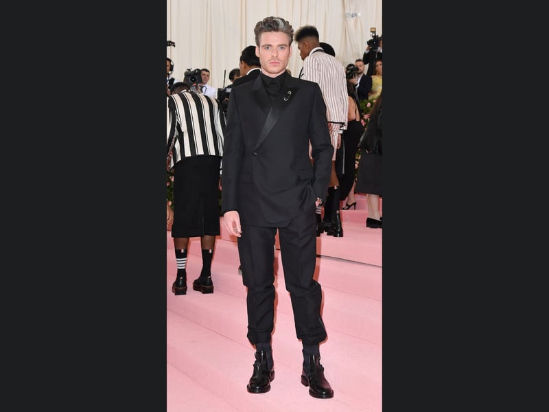 One of two Met Gala appearances, Richard Madden’s trousers tucked into socks outfit was worn to the 2019 event themed “Camp: Notes on Fashion”.
