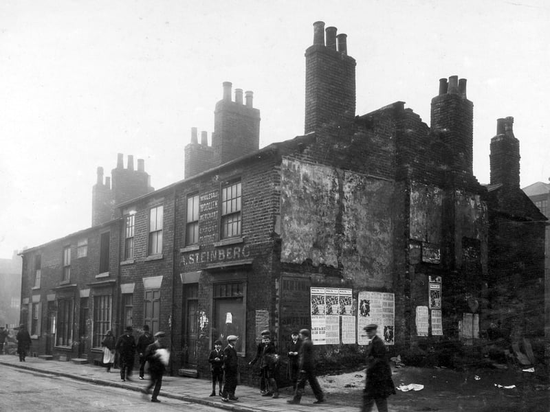 Shop, houses etc in Bridge Street to be demolished. Shop is A Steinberg, wholesale woollen merchant. Posters on end wall. Pictured in October 1930.