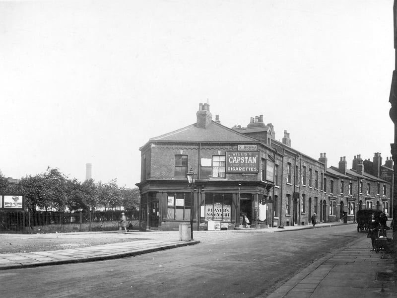 Portland Street in July 1930.  In the centre is No 2 Portland Street, premises of W.H Robinson who had a hairdressing and tobacconists business. Barbers poles can be seen at the doorway. The adjoining shop has notice calling the attention of Seaman and Miners. Portland Crescent runs to the right. Two girls can be seen with dolls pram on the right pavement.