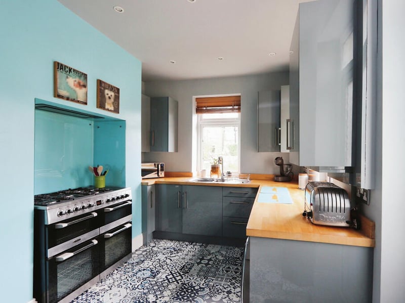 The kitchen, with bright walls around the oven and tiled floors, almost has a holiday feel.
