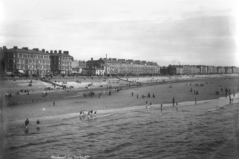 The beach at Blackpool, 1890-1910. A view looking inland across the beach with holidaymakers paddling in the sea