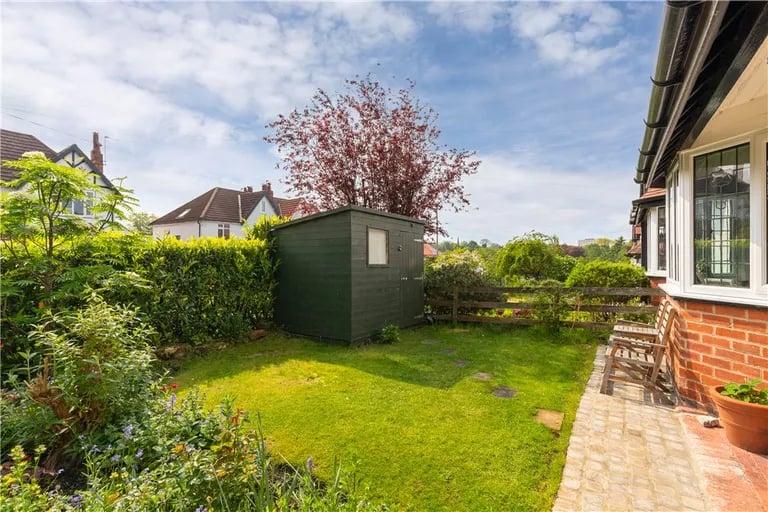 To the front is a landscaped garden with shed.