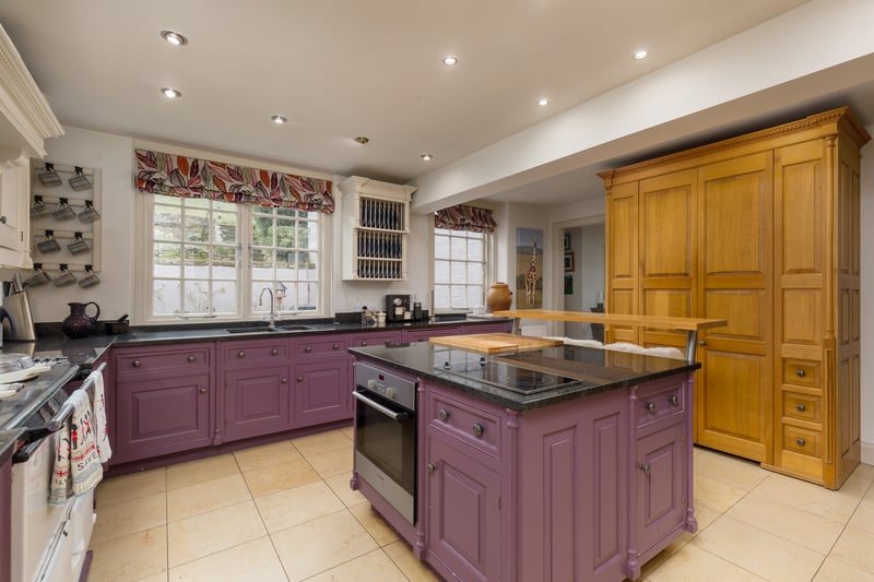 The kitchen, by Wiltshire-based luxury designer Smallbone of Devizes, features an Aga range and leads to a smaller family room warmed by a wood-burning stove.