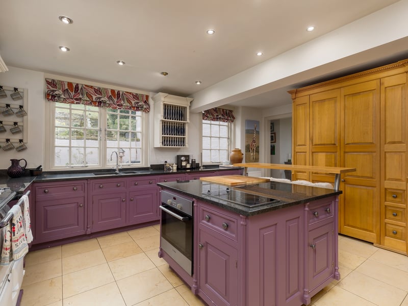 The kitchen, by Wiltshire-based luxury designer Smallbone of Devizes, features an Aga range and leads to a smaller family room warmed by a wood-burning stove.