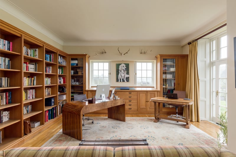 A library/study to the rear of the house features elegant double doors which fill to room with sunlight and open directly to the outside space.