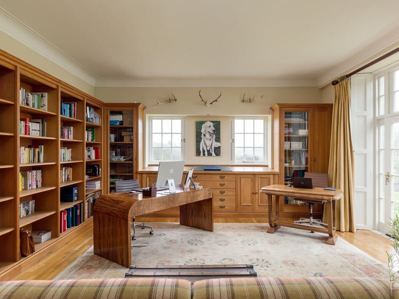A library/study to the rear of the house features elegant double doors which fill to room with sunlight and open directly to the outside space.