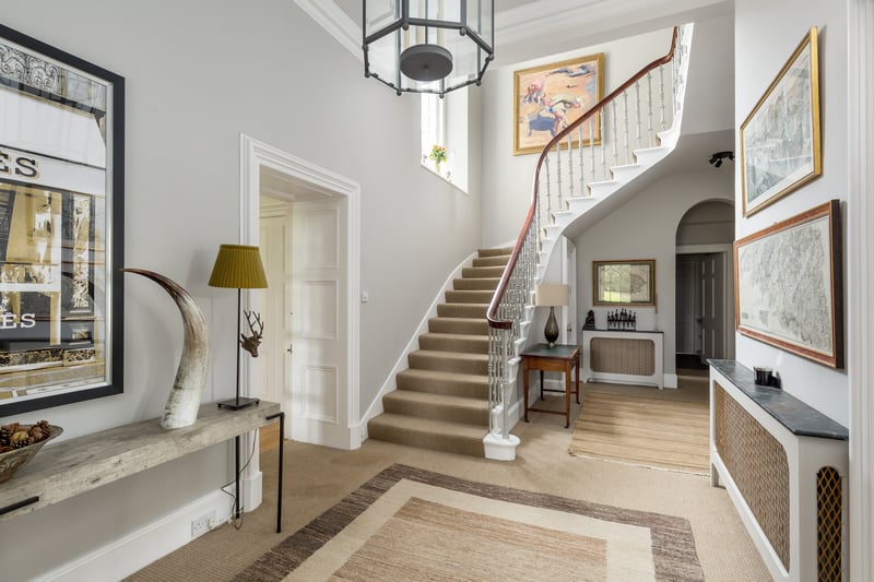 A welcoming reception foyer, with a large window illuminating all above a splendid curving staircase, sets the tone of the house upon entering.