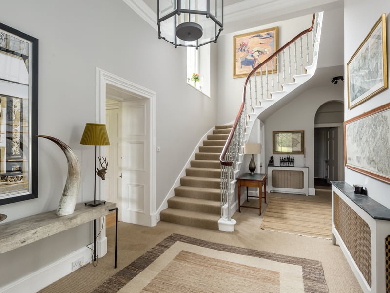 A welcoming reception foyer, with a large window illuminating all above a splendid curving staircase, sets the tone of the house upon entering.