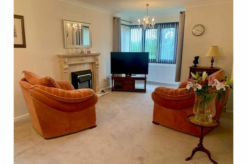 The lounge is carpeted and cosy, with a feature fireplace.