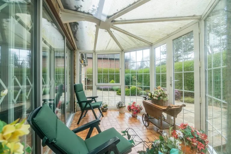 The sliding doors open onto this sun room with panoramic views of the private rear garden.