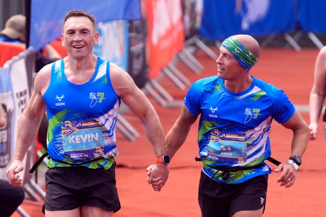 Kevin Sinfield and David Spencer (right) cross the line to complete the Rob Burrow Leeds Marathon. 