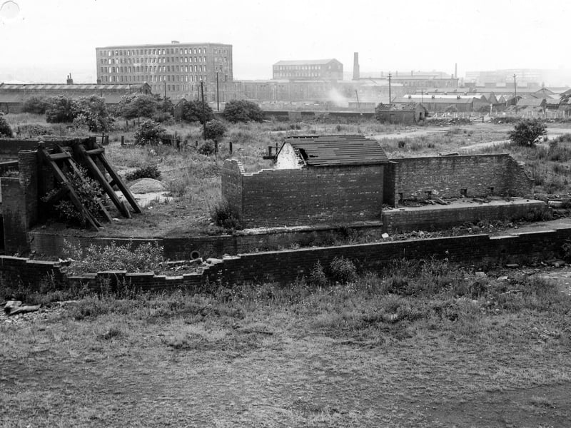 An area of wasteland off East Street with derelict brick buildings in the foreground, and factories in the background. Pictured in October 1978.