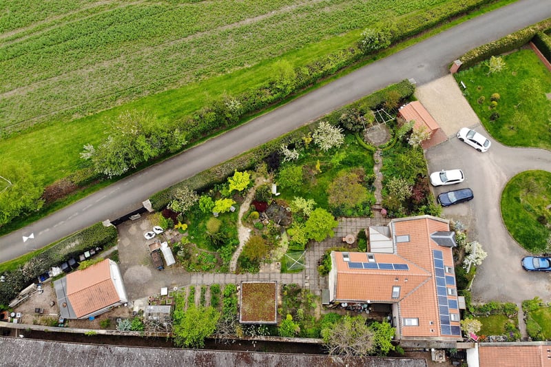 The property has a large garden with a path leading to a double garage.