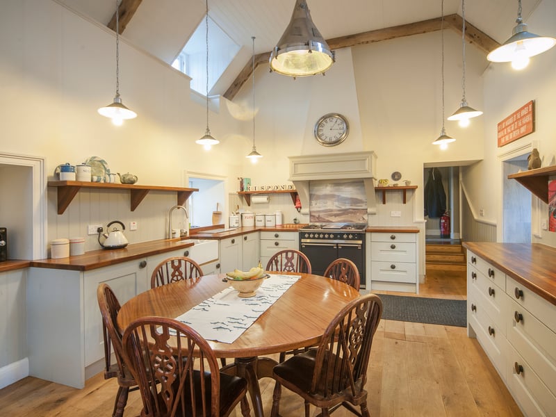 The kitchen features high ceilings and a range-style cooker