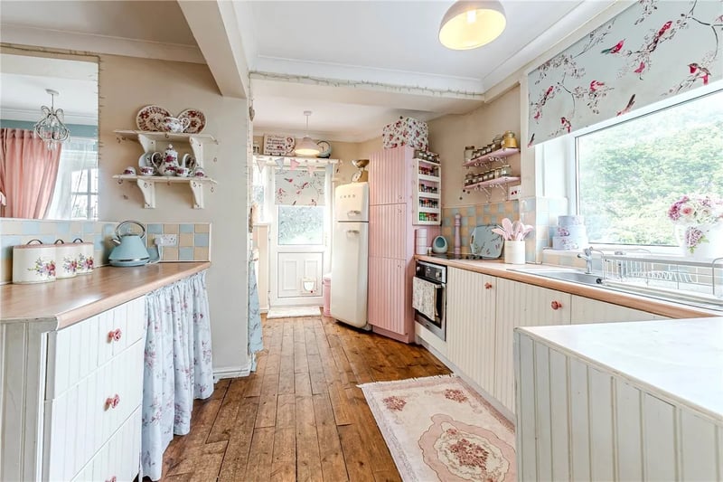 Double doors lead into the open plan and extended dining kitchen with a range of handmade base and wall storage units, a built in oven and hob, and ample dining space.