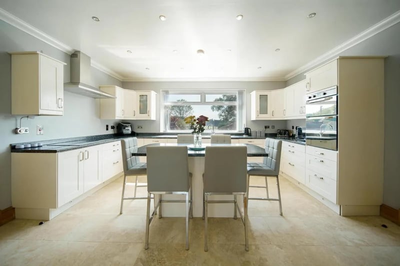 The open-plan kitchen/living/dining area includes integrated appliances and marble flooring throughout.