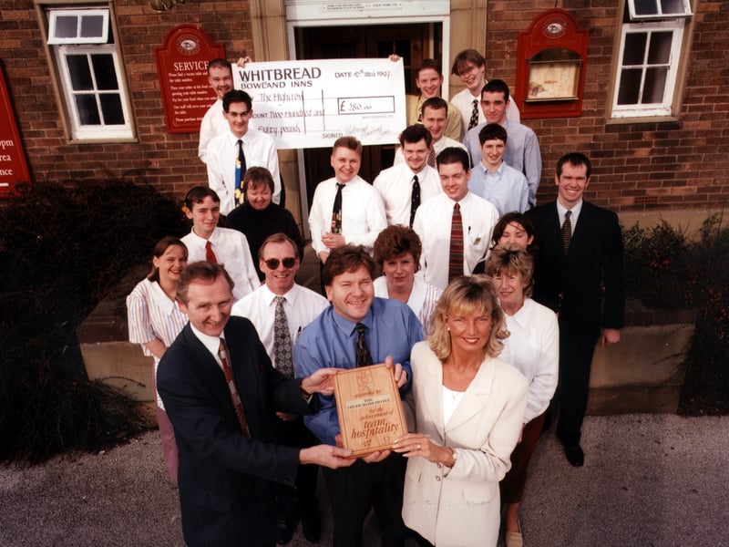 Whitbread Bowland Inns' operations manager, Richard Walker (front left) is seen presenting licensees Les and Debbie Cox and their team of staff with the Team Hospitality award