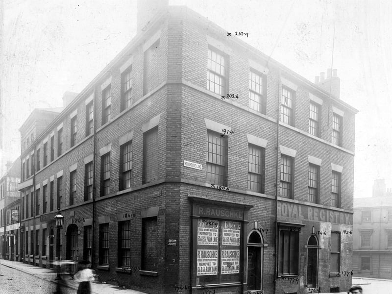 Facing Woodhouse Lane premises of R.Rauschke surgical instrument maker with notices in window about removal to Park Lane.Next door are premises with name Royal Registry painted along front.Along Kelsall Street can be seen premises of Walter Shepherd and Co.Woollen Merchants, with Thomas Briggs and Sons Carpet Cleaning works next doo Pictured in September 1903.