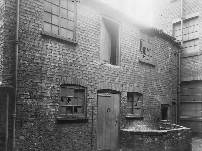Close up view of yard at rear of Kelsall Street off Woodhouse Lane showing small walled enclosure and door with horse shoe nailed to it (upside down). Upper floor has door above the ground floor door. P{ictured in September 1903.