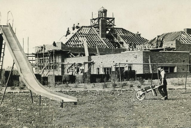 Work proceeding on the new library and maternity and child welfare clinic at the corner of Devonshire Road and Bispham Road. The children's playground on Devonshire Road is in the foreground, 1937 