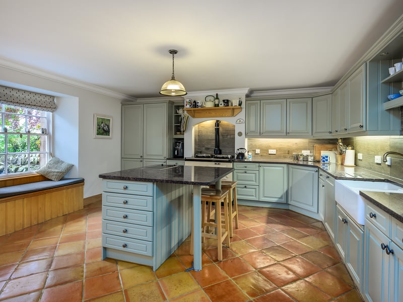 The renovation involved transforming a lower ground-floor annexe flat into an open-plan traditional-style kitchen and dining room which forms the heart of the home, and features a cream Aga, painted timber cabinets and terracotta tiled flooring.