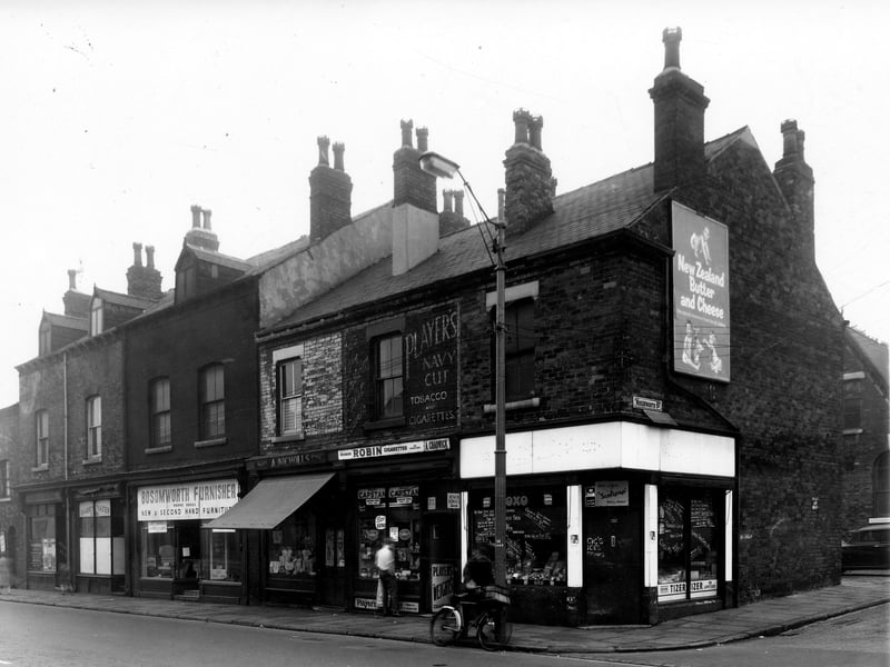 The first shop on the left is number 202 Kirkstall Road, premises of W.N. Howden, engraver. Next 200 is Harry Yates and son, leather goods manufacturers. Bosomworth Furnisher offering new and second-hand goods is 198. At 196 Ada Nicholls has a drapers shop, 194 is Ada Chadwick selling tobacco and cigarettes. At the corner with Wordsworth Street on the right is H. Harrison, greengrocer. Pictured in October 1959.