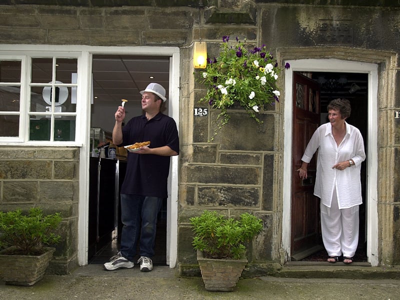 Mark Savage at the Village Fish Shop on Main Street watched by his mum Hazel in July 2003.