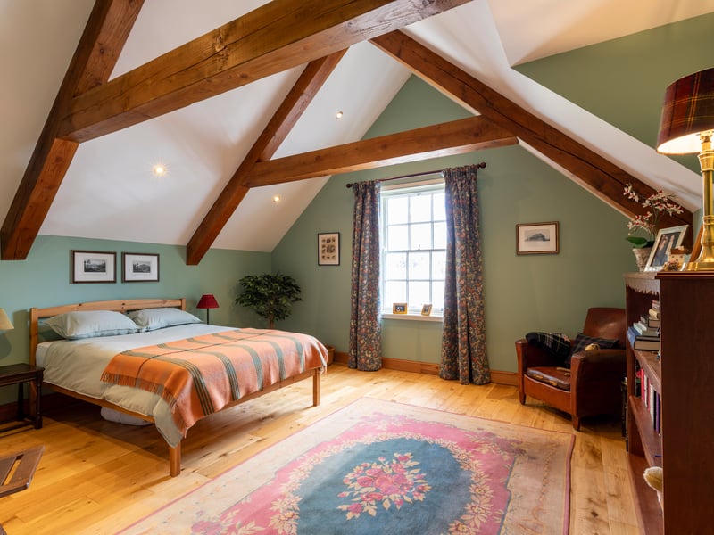 Exposed wooden beams add character to this generously-proportioned double bedroom.